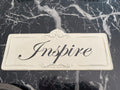 Cream colored "Inspire" metal sign