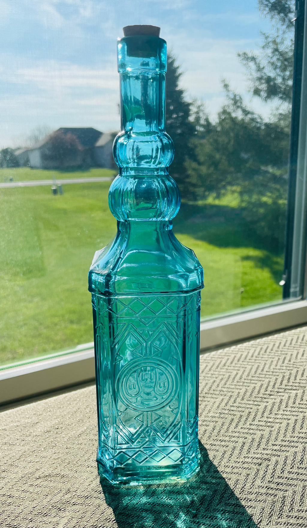 Beautiful teal embossed glass bottle